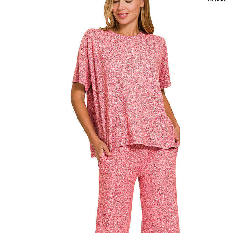 Woman wearing a pink outfit with a top and pants on a white background