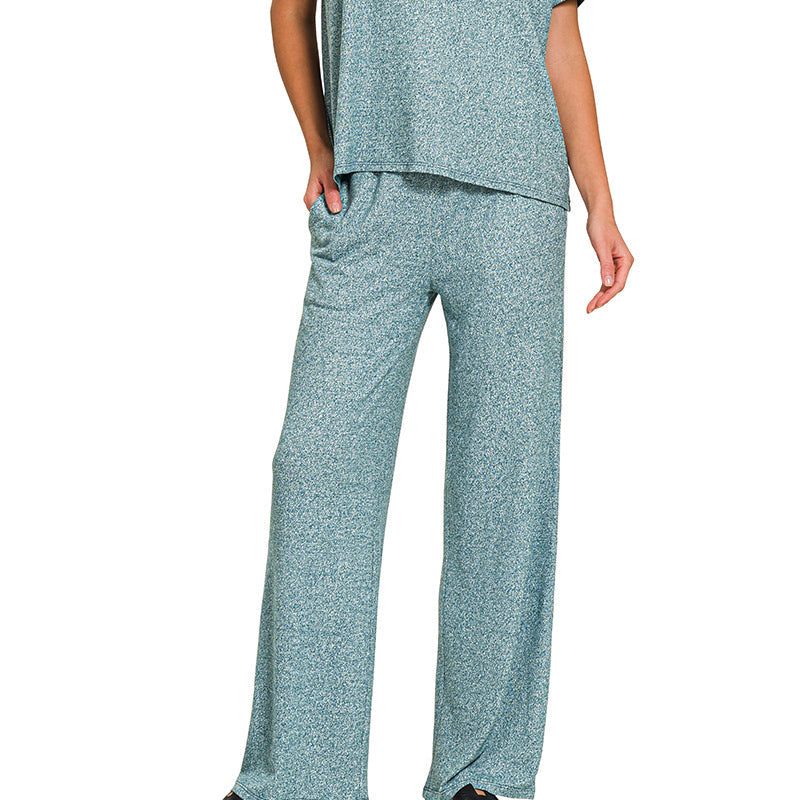 Woman wearing a teal pajama set on a white background