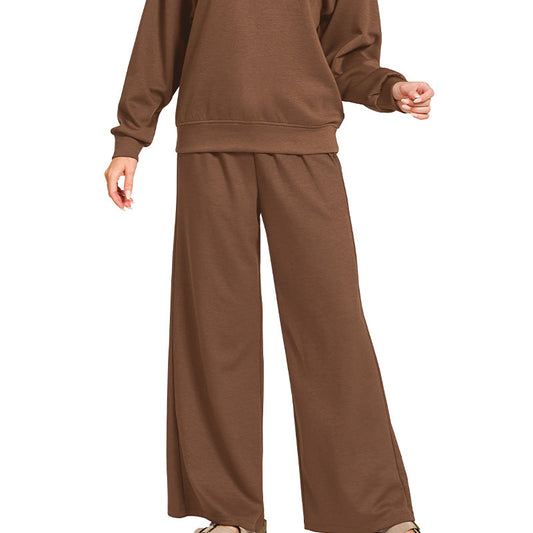 Woman wearing a brown sweatshirt and pants set on a white background
