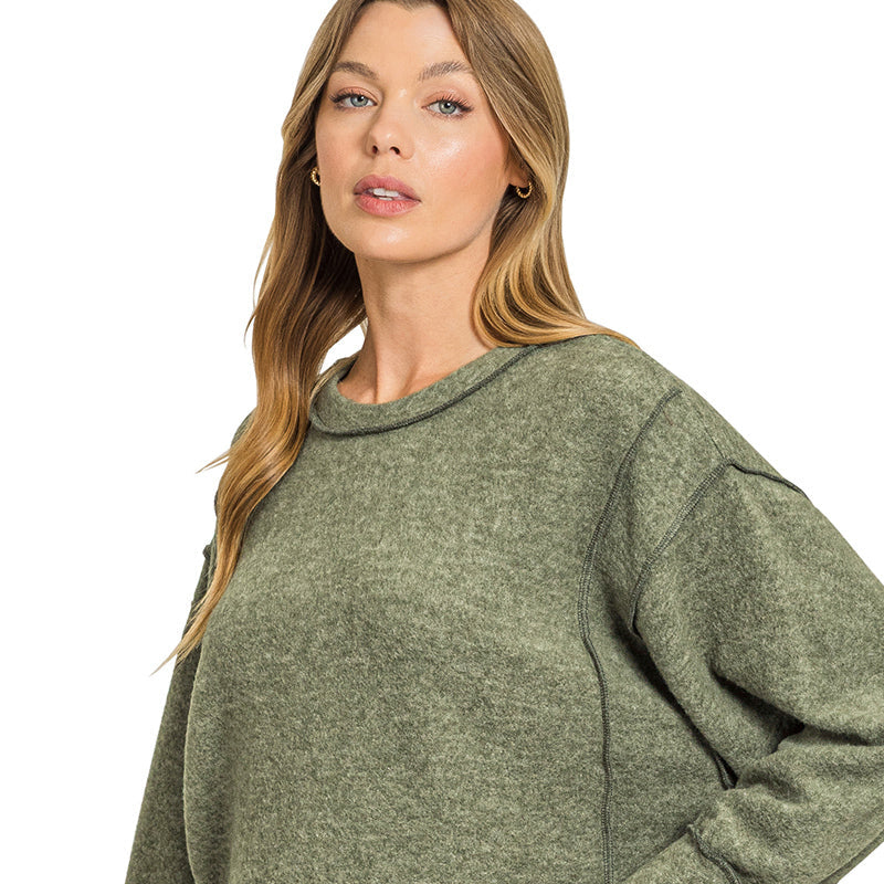 Woman wearing a green sweater with text 'DK OLIVE' at the bottom right corner.
