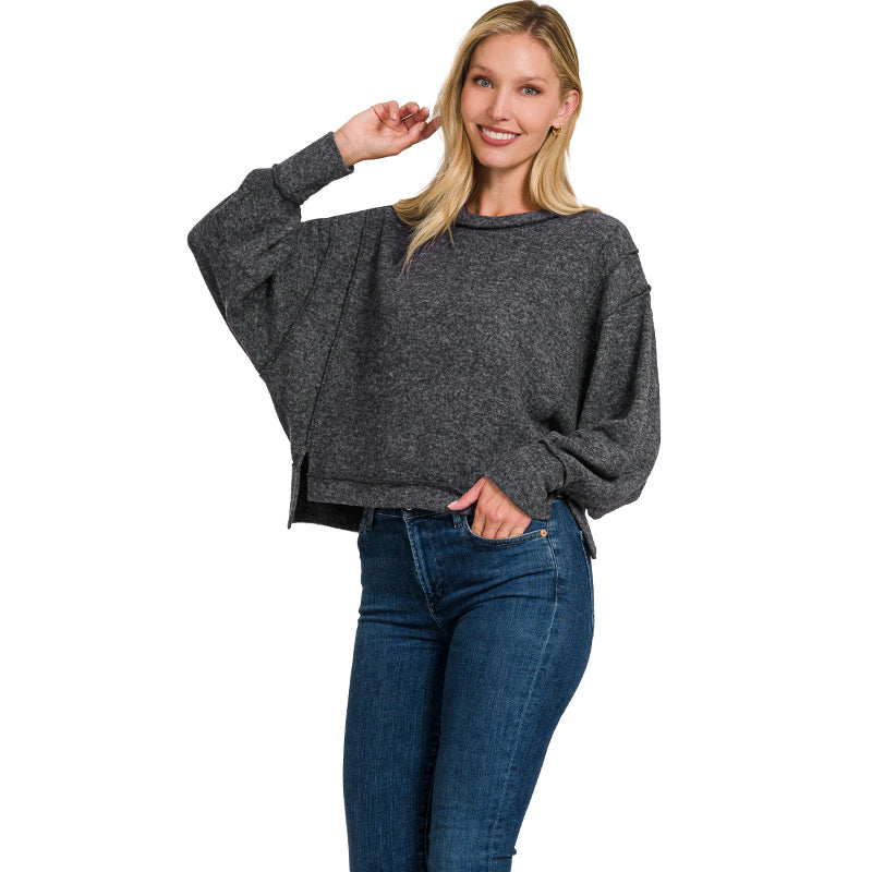 Woman wearing a gray sweater and blue jeans on a white background