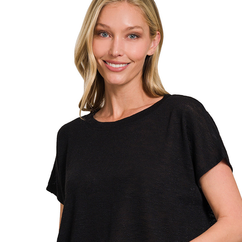 Woman wearing a black top and blue jeans on a white background