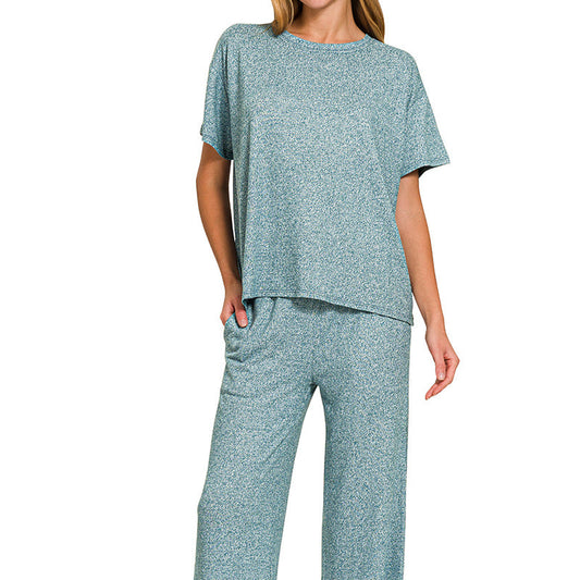 Woman wearing a teal pajama set on a white background