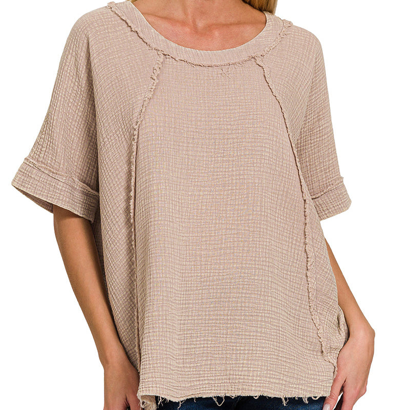 Woman wearing a beige textured top with a plain background