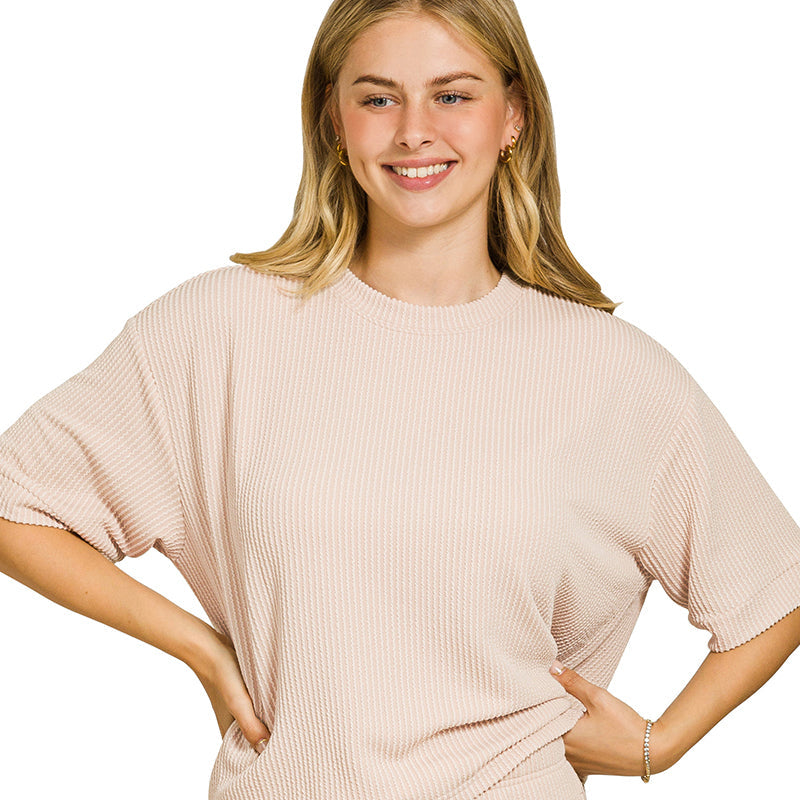 Woman wearing a sand beige ribbed lounge set on a white background