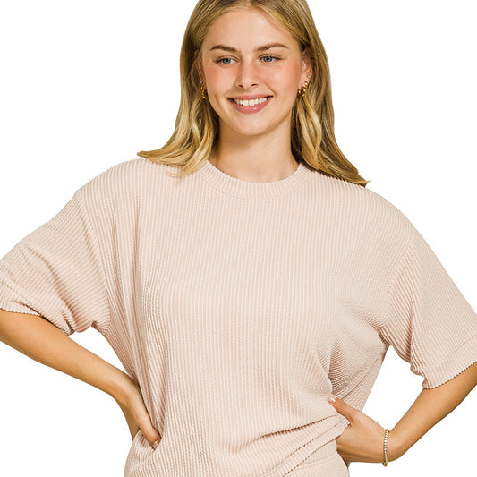 Woman wearing a sand beige ribbed lounge set on a white background