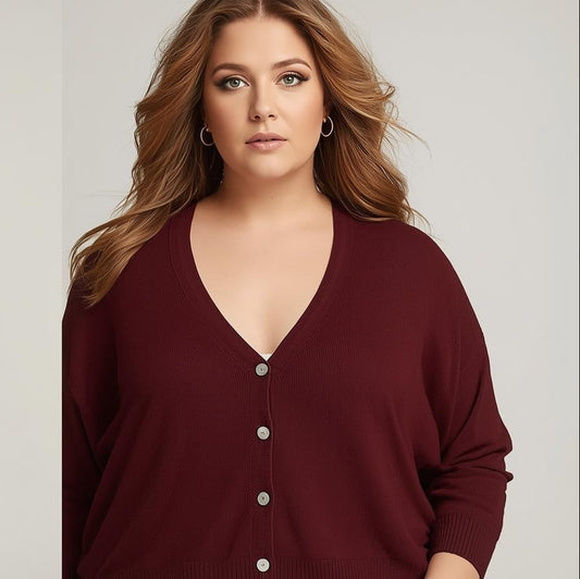  woman wearing a beige tank top and black jeans, and a burgundy cardigan with buttons.